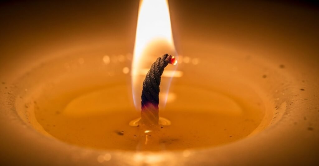 A detailed, high-resolution close-up of a candle's wick, showing the intricate details of the burning wick and the melted wax around it. By bathandbodyworkscandles.store